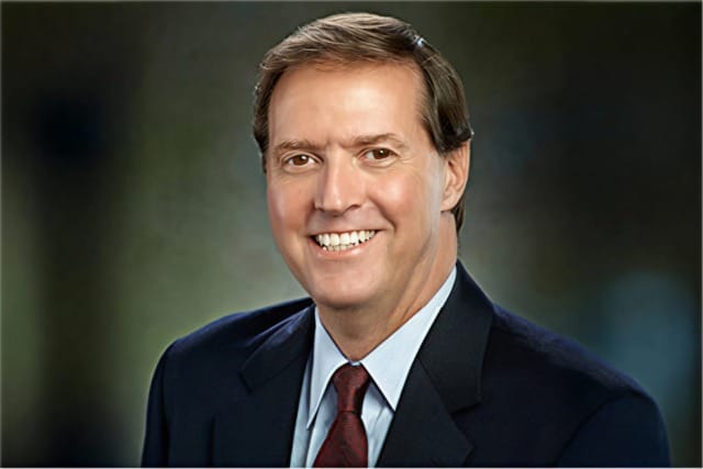 Smiling man in a suit and tie with a blurred background