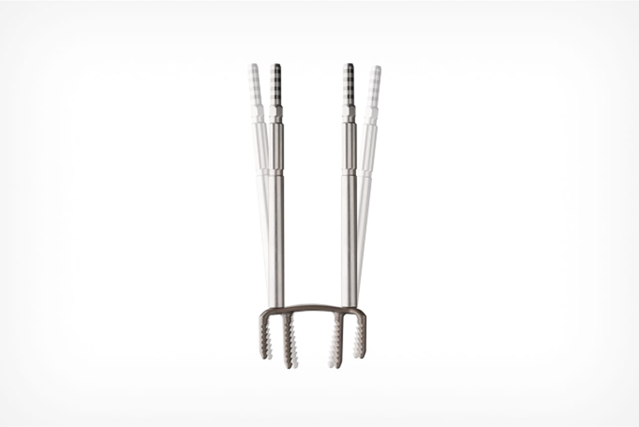 Silver metal grooming tool with three prongs, designed for scalp massage and relaxation, isolated on a white background.